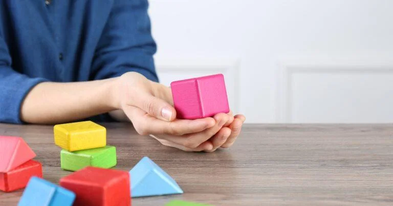 ABA therapist showing how to play with building blocks.